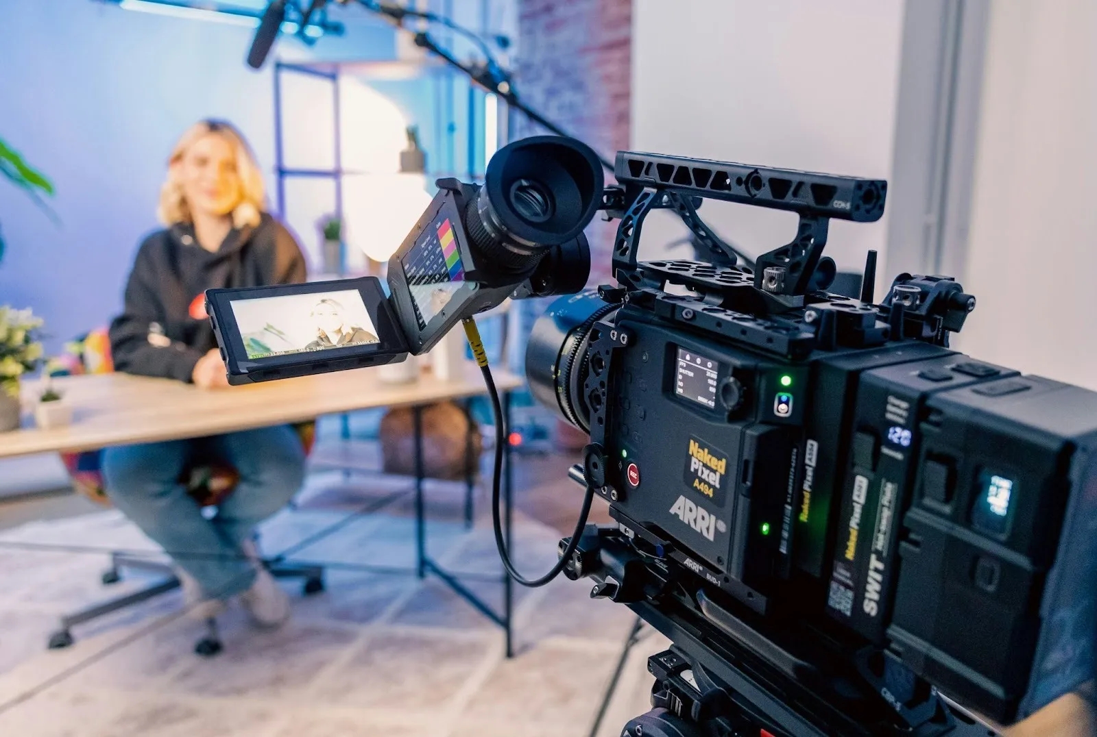 Professional ARRI camera recording a video interview in a modern studio setting.
